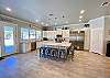 A chefs dream kitchen with super sized kitchen island with barstools, commercial grade frig, views of the pool, large pantry, tile floors.