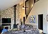 Vaulted ceiling, rock wall, wood burning stove, upscale decor.