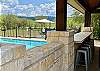 Massive timber beams, rock bar with bar stool seating overlooking the pool and mountain range.