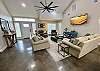 Huge living room with upscale comfy furniture, vaulted ceiling and stained concrete floors.