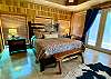 Bedroom 1 - steps from pool, King bed, upscale western furnishings, cowhide rug, french door to covered porch, views.