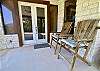 Bedroom 2 has private covered porch with chairs.