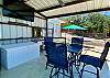 Poolside covered Cabana has table & chairs, sink, tv and half bathroom.