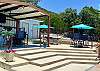 Covered Poolside Cabana: TV, sink, frig, table, chairs, party lights.