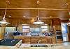Luxury Kitchen has pretty lighting, granite kitchen countertops, custom cabinets, dishwasher, griddle, pot filler and stainless frig.