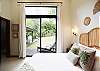 1 Queen-sized bedroom that includes a terrace that opens to the patio and green areas.