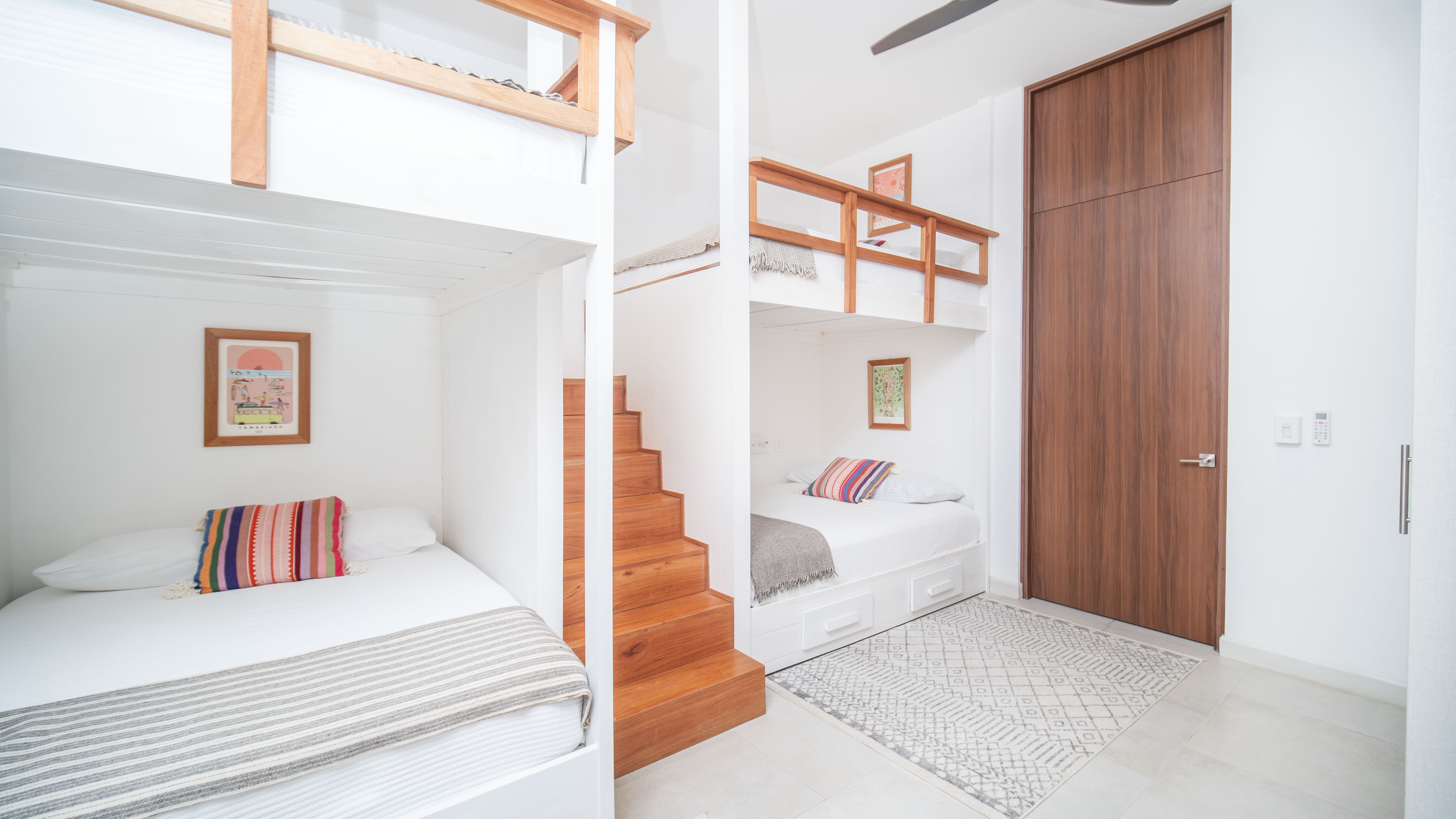Wooden stairs with framed art leading to an upper level beds