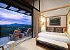 King-size bed facing floor-to-ceiling windows and natural light