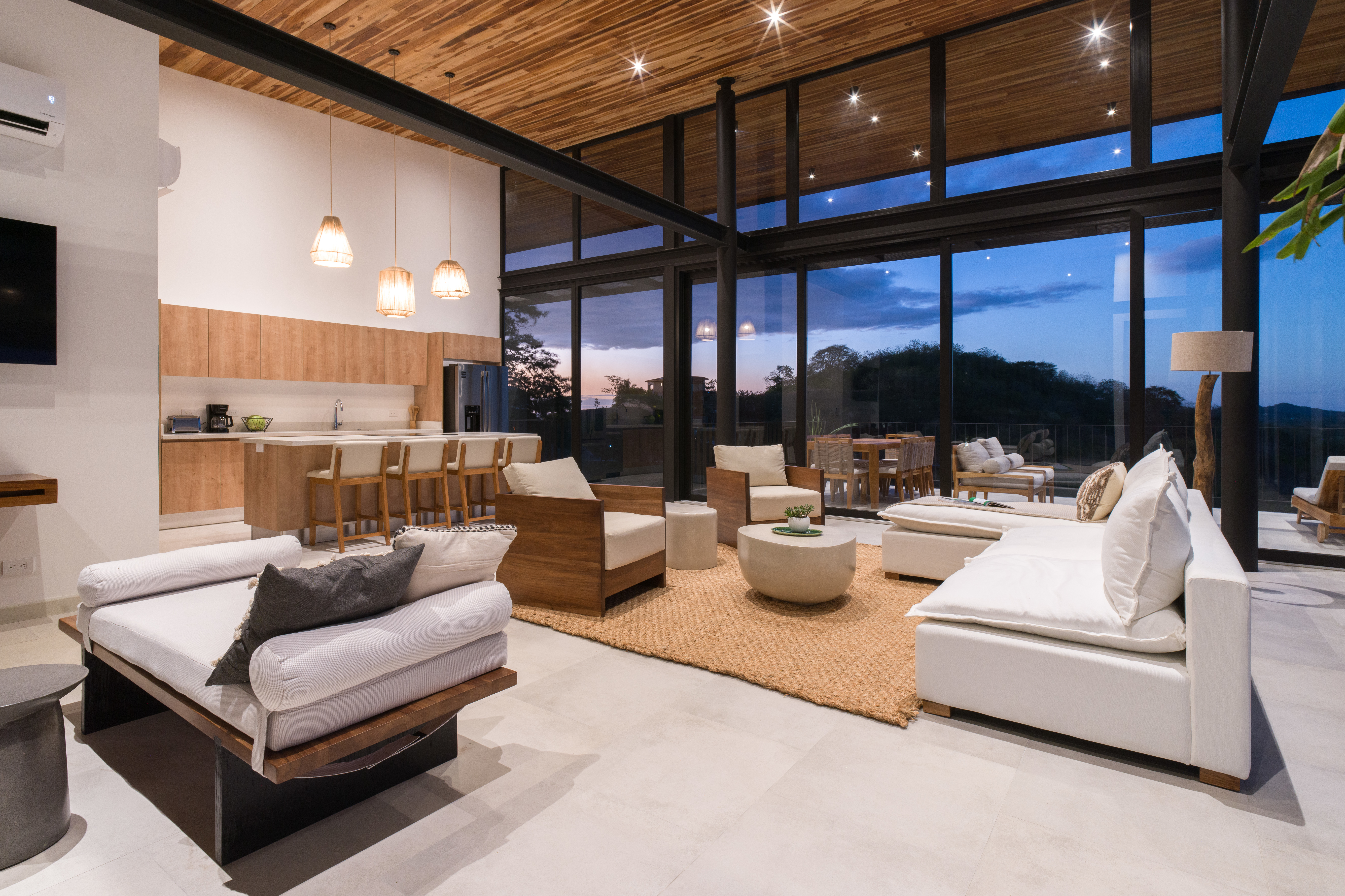 Open-concept living area with exposed beams and view
