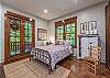 Queen bedroom with doors out to deck and patio area.