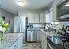 Kitchen includes stainless appliances, smooth surface stove, and