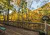 Main level deck w/ picnic tables overlooking creek.