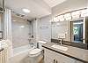 Start your morning in a bright, updated bathroom with a spacious vanity, well-lit mirror, and convenient access from the bedroom.