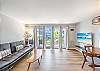 Bright, airy, and welcoming—this open living space offers a perfect spot to relax after a beach day, complete with balcony access and comfortable seating.