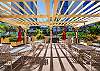 Share island-style meals at the community BBQ area, where palm-lined views and open-air dining set the mood for a relaxing evening.