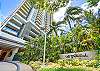 Palm trees and tropical landscaping frame the driveway entrance and modern residential tower at The Watermark Waikiki, identifying the 1551 Ala Wai Boulevard setting of this 35th-floor monthly rental in Honolulu.