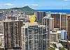 A closer aerial perspective identifies The Watermark among western Waikiki’s residential towers, while Diamond Head and the Pacific Ocean provide recognizable Honolulu context beyond the yellow building marker.