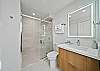 Refresh in a sleek primary bathroom featuring a glass walk-in shower and contemporary finishes—ideal for starting your Waikiki mornings with ease.