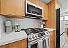 Prepare island-inspired meals in a thoughtfully updated kitchen featuring a gas stove, full-size refrigerator, and warm wood cabinetry—perfect for extended stays in Waikiki.