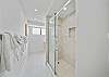 Freshen up in a clean, modern hall bathroom featuring a spacious walk-in shower—an added convenience for guests staying in the second bedroom.