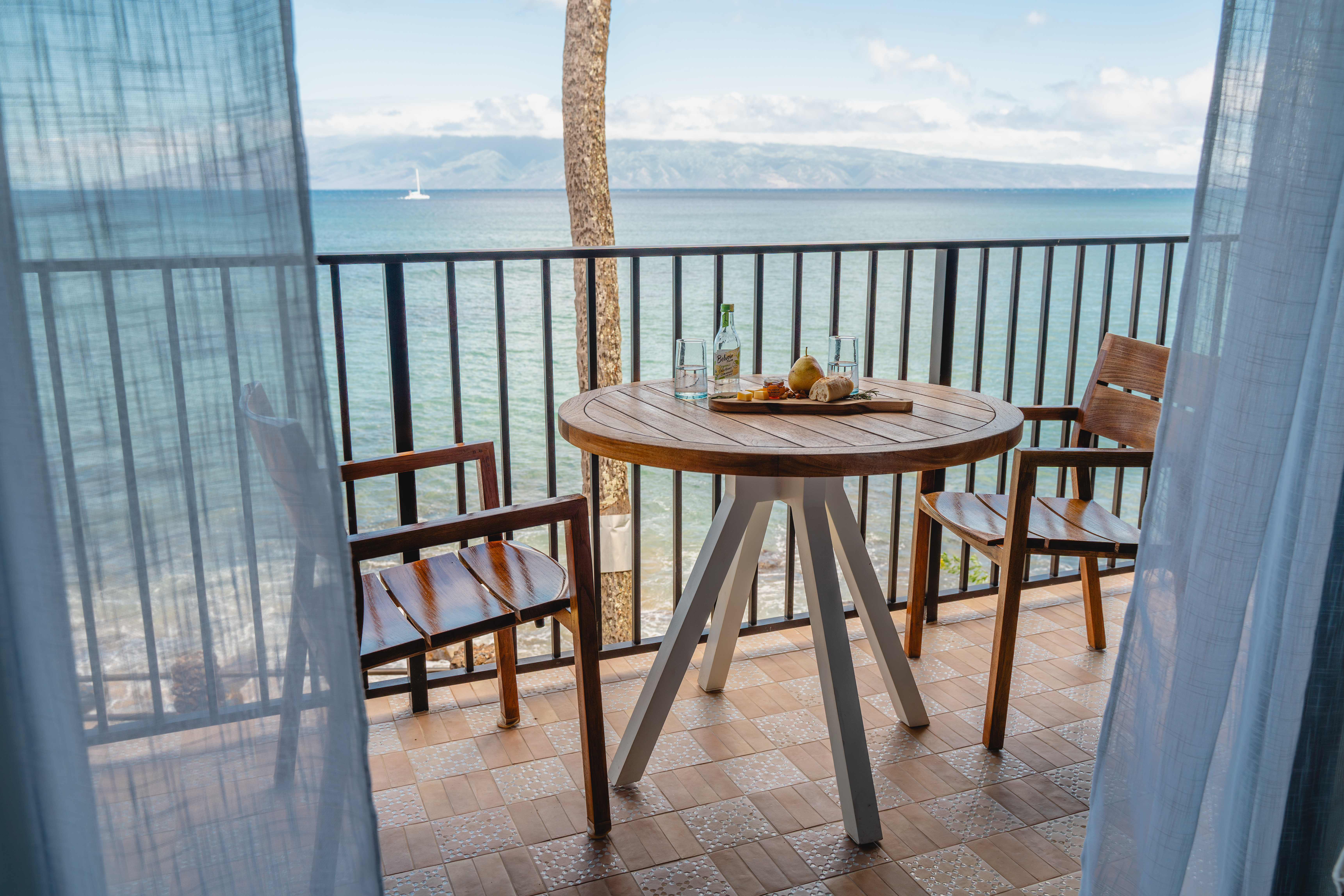 Guests enjoying whale watching from the private lanai of Noelani 219 during Maui’s whale season, with binoculars provided for an unforgettable experience.
