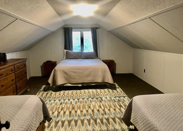 Upper-level bedroom with three beds. 