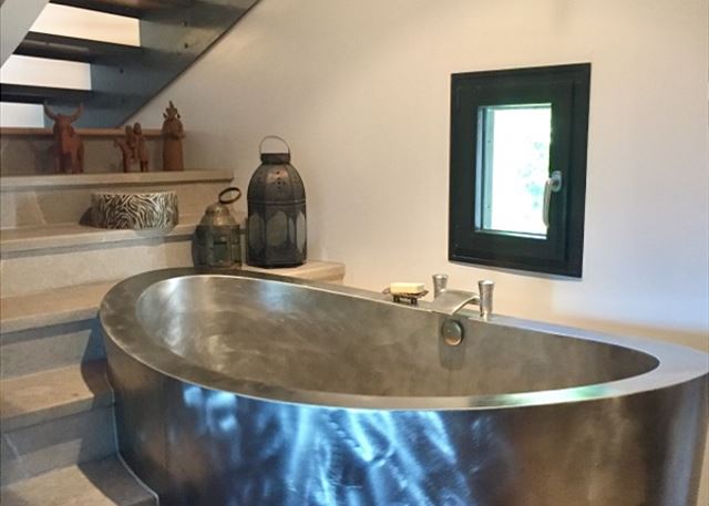 Soaking tub for two. On upper level, kind of, you go up about 7 steps, then off to the right, and back down about 7 steps to the bathroom, tub in some of the steps. Fire place visible from this side of it too 