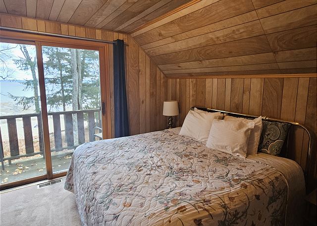 Upstairs bedroom with king bed and balcony