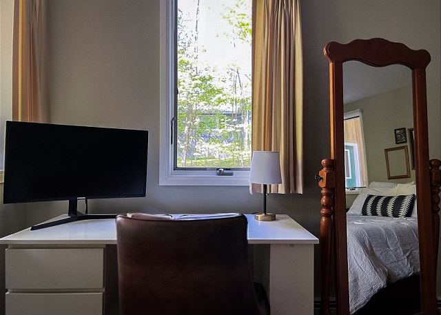 Computer monitor and desk in ground floor queen bedroom