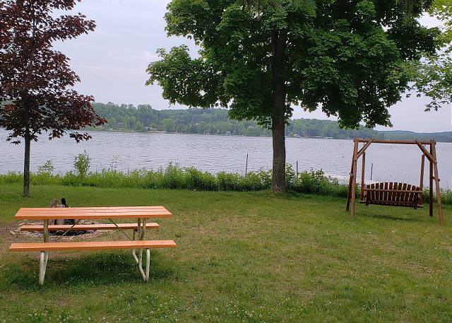 Gas grill, fire pit, row boat, canoe, paddleboat, life jackets (adults), dock, grassy lawn.
