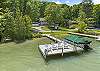 House is set back behind the trees to the left of the dock