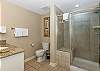 The guest bathroom is directly across from the guest bedroom and boasts a sizable glass enclosed shower.