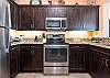 Wonderfully equipped kitchen with beautiful dark wood cabinets, granite and stainless steel appliances.
