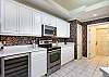 Bright kitchen with corian counters and stainless steel appliances including a wine fridge!
