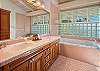 Primary ensuite bathroom with shower and jetted tub