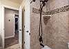The upstairs hallway bathroom has tub shower combo with a dual shower head.