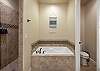 Let your worries soak away while relaxing in the large main bathtub and spacious walk-in shower with dual showerheads. 
