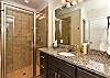 Bathroom 2 includes a large walk-in shower, sink, toilet, and vanity.