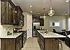 Side view of kitchen showing off the beautiful counter tops and stainless-steel appliances. 