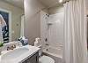 Bathroom 4 is located adjacent to the Loft and includes a combination tub and shower, toilet, vanity, and closet.