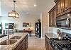 Side view of kitchen showing off the beautiful counter tops and stainless-steel appliances. 