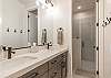 Fish Rock Bathroom includes a large walk-in shower, his and hers sinks, toilet, and vanity.
