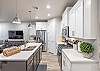 Side view of kitchen showing off the beautiful counter tops and stainless-steel appliances. 