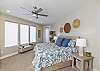 The primary bedroom on the main floor is furnished with a plush King bed, private TV, attached luxurious bathroom, and large walk-in closet. 