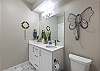 Bathroom 4 adjoins the lower level family room and services bedroom 4. It includes double sinks and a large walk-in shower.