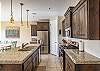 Side view of kitchen showing off the beautiful counter tops and stainless-steel appliances. 