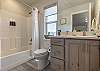 Bathroom 5 is located off the upstairs loft and includes a tub/shower combo, sink, toilet, and vanity.