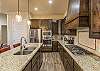 Side view of kitchen showing off the beautiful counter tops and stainless-steel appliances. 