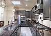 Side view of kitchen showing off the beautiful counter tops and stainless-steel appliances. 