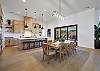 The Kitchen and Dining Table can accommodate 13 adults, 8 at the table and 5 at the bar stools, and is stocked with pots, pans, baking sheets, mixing bowls, plates, bowls, cups, silverware, and a collection of cooking utensils.